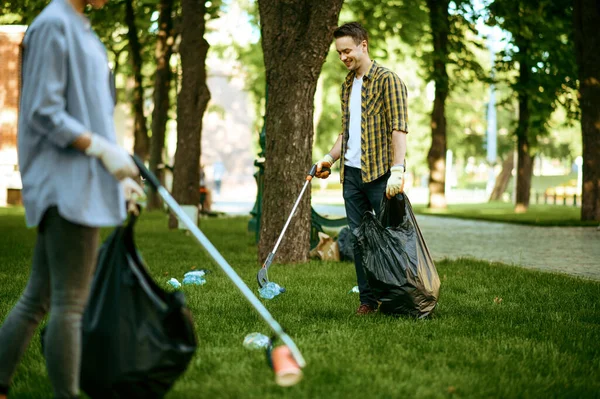 İki adam parktaki poşetlerde gönüllü olarak plastik çöp topluyor. Erkek kişi ormanı temizler, ekolojik restorasyon, ekolojik yaşam tarzı, çöp toplama ve geri dönüşüm, ekoloji bakımı, çevre temizliği