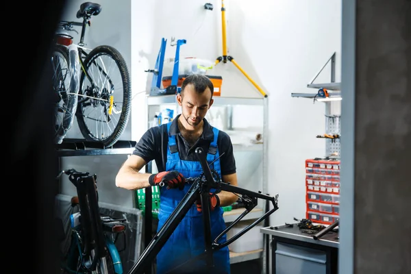 ワークショップでの自転車修理クランクを固定する男 サイクル プロの自転車修理サービスで均一な修正問題の機械 — ストック写真