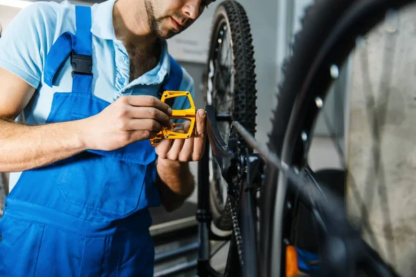 Naprawa Rowerów Warsztacie Człowiek Instaluje Pedały Mechanik Mundurze Naprawić Problemy — Zdjęcie stockowe