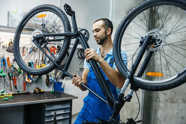 Atölyede Bisiklet Tamiri Adam Mekanizmaları Kontrol Ediyor Üniformalı Tamirci Bisikletli — Stok fotoğraf