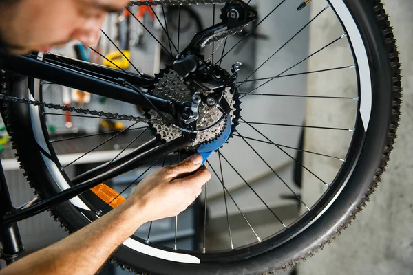 ワークショップで自転車修理 男のカセットの閉鎖を設定します サイクル プロの自転車修理サービスで均一な修正問題の機械 — ストック写真