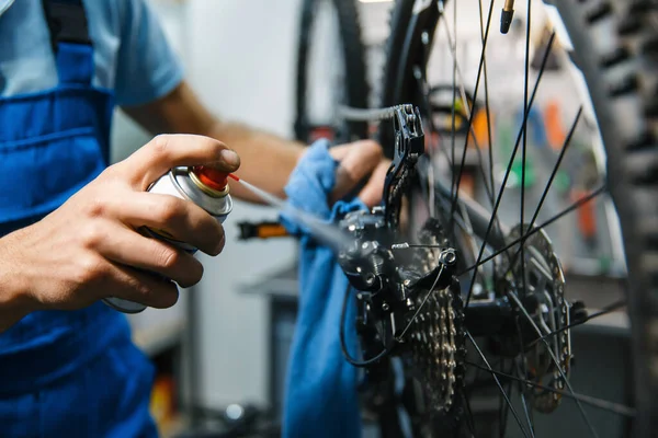 ワークショップでの自転車修理 男はスターカセットをクリーンアップします サイクル プロの自転車修理サービスで均一な修正問題の機械 — ストック写真