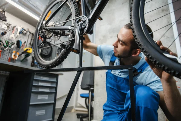 Fahrradreparatur Der Werkstatt Mann Überprüft Rad Auf Gegenspiel Mechaniker Uniform — Stockfoto