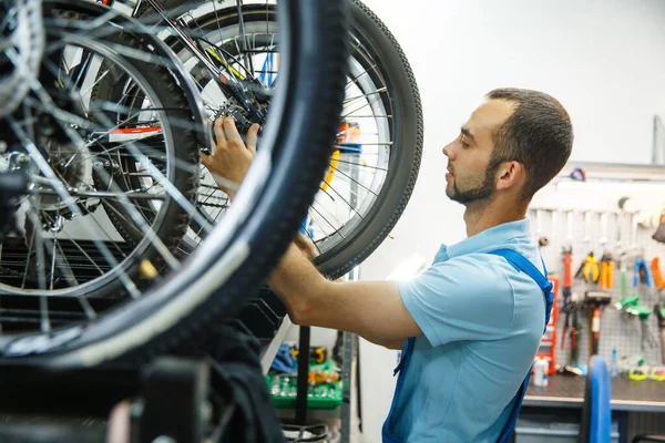 自転車のワークショップ 男の組み立てを終えた サイクル プロの自転車修理サービスで均一な修正問題の機械 — ストック写真