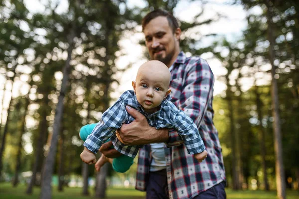 父は夏の公園で赤ん坊と遊ぶ 芝生の上で男の子供とお父さん 森の中で遊ぶ子供とピクニック 家族の幸せ — ストック写真