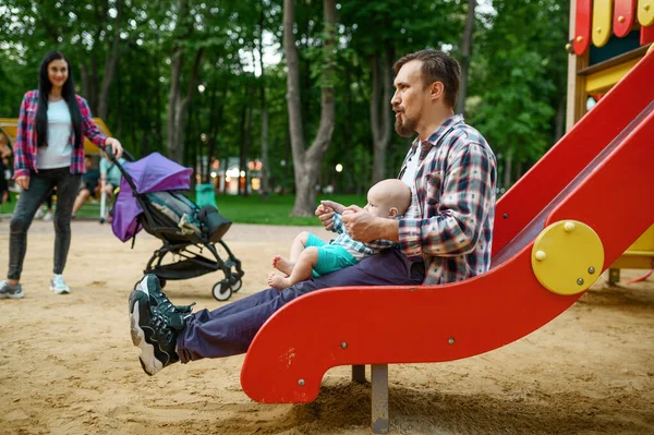 夏の公園の遊び場で小さな赤ちゃんと幸せな両親が遊んでいます ママとパパのレジャーと男性の子供 森の中の子供とピクニック 家族の幸せ — ストック写真