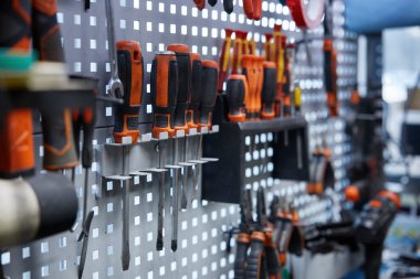 Duvarda belirgin bir şekilde çeşitli şekilleri ve işlevlerini herkesin görmesi için gösteren çeşitli aletler koleksiyonu asılıdır.