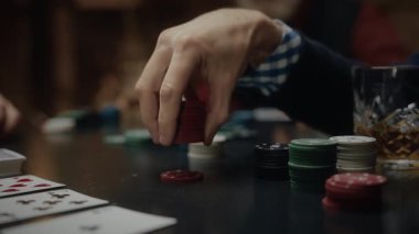 Erkek el poker çiplerini masanın üstünde tutuyor, oyuna hazırlanıyor.