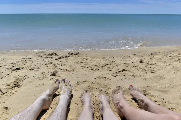 Ноги Трьох Людей Лежать Піску Перед Морем — стокове фото