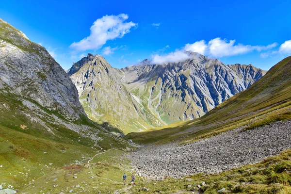 Gran Vista Las Montañas Dos Excursionistas Caminando Valle —  Fotos de Stock