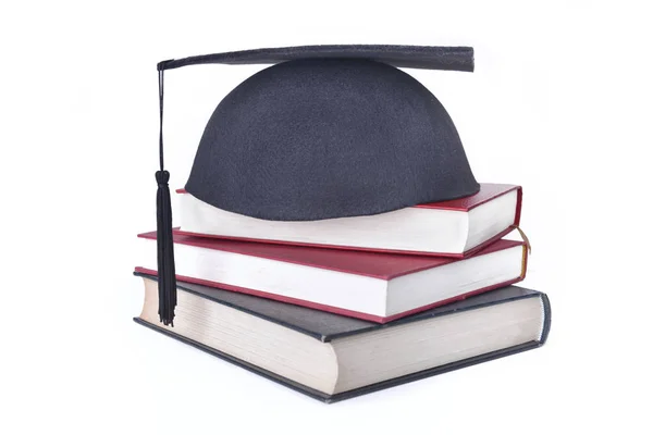 Φοιτητής μαύρο καπάκι βάλει βιβλία στοιβάζονται απομονωθεί σε λευκό φόντο — Φωτογραφία Αρχείου