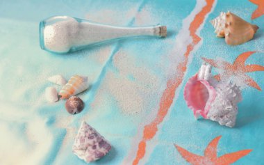 bir plaj havlusu üzerinde küçük bir şişe ve tropikal deniz kabukları kum 