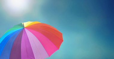 Gökkuşağı şemsiye güneşli mavi gökyüzü altında