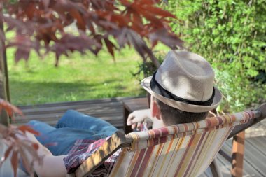 Bahçedeki şezlongda uyuyan genç adam manzarası 