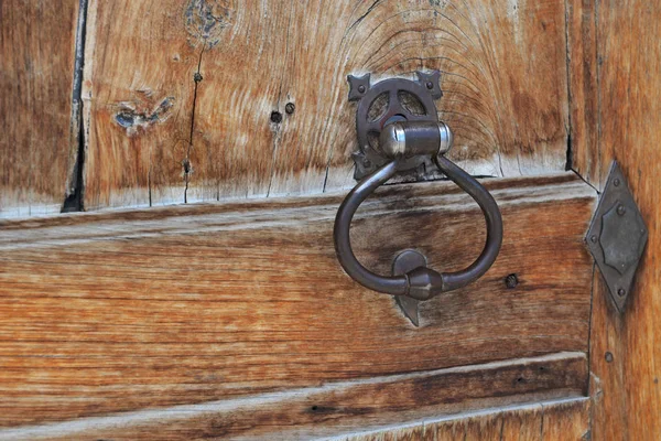 Fechar em metal bater em uma velha porta de madeira — Fotografia de Stock