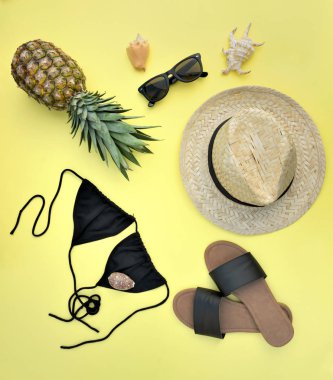 sarı arka plan- yaz tatili konsepti ananas ile plaj aksesuarları üst görünümü 