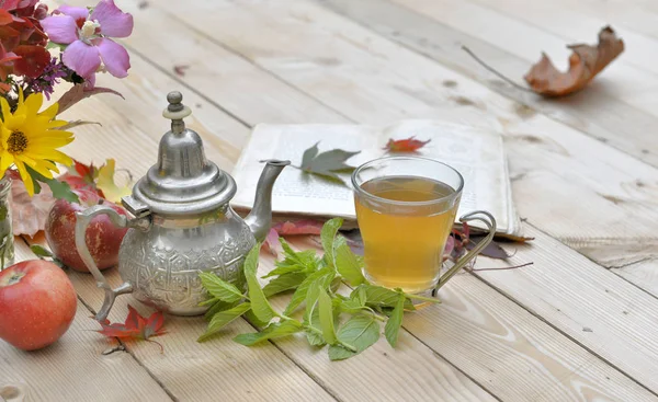 Secangkir teh mint dengan bunga dan daun mint di atas meja — Stok Foto
