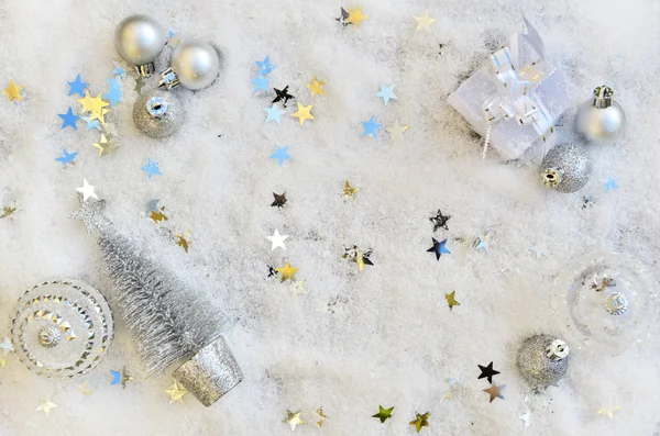 Top view on christmas ornament and little colorful stars on snow — Stock Photo, Image