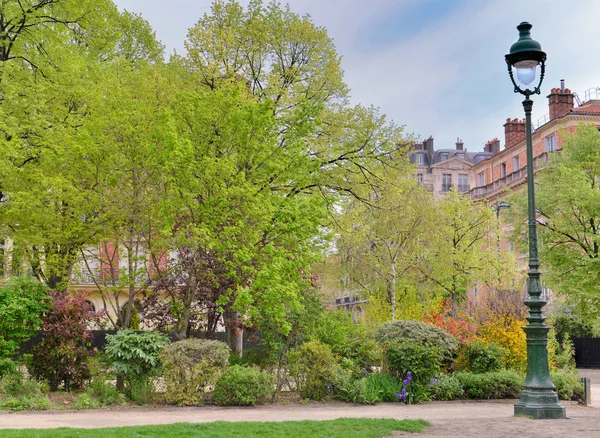 Park next to Eiffel tower in paris with a retro lamppost front of building — Stock Photo, Image