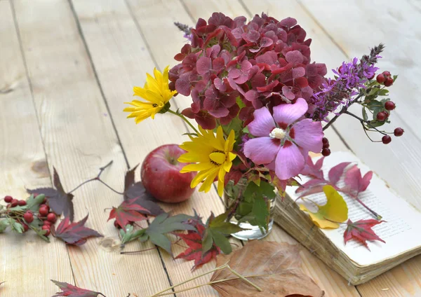El ramo de las flores con los colores hermosos otoñales sobre la mesa en las hojas —  Fotos de Stock
