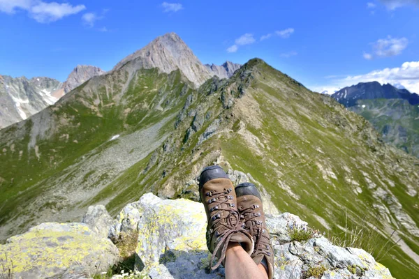 View on hiking shoes wearing by a woman sitting in mountain in beautiful landscape — Stock Photo, Image