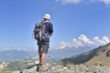 bir yaz alp dağının zirvesinde duran yürüyüşçü 