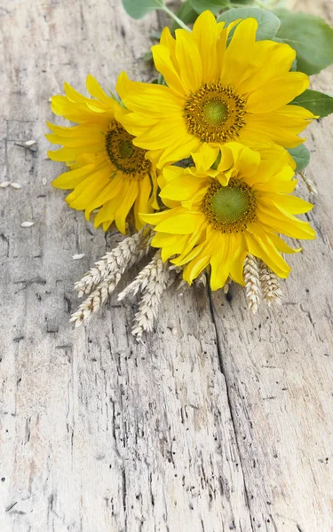 Bouquet of sunflowers with dry wheat on a rustic table — Stock Photo, Image