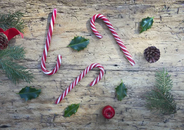 Vue de dessus sur cannes à bonbons et décoration de Noël sur fond de bois rustique — Photo