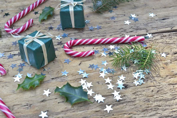 Cannes à bonbons et décoration de Noël en forme d'étoile confettis sur rustique — Photo