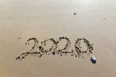 yıl 2020 plaja kum üzerinde bir çakıl taşı ile el yazma