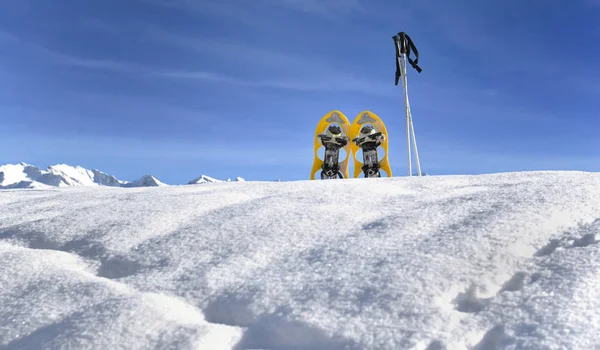 Sneeuwschoenen in de sneeuw op de top van de berg onder de blauwe hemel — Stockfoto