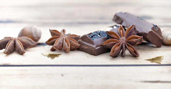Close on Star anijs met Chocolat en christment confetti op houten achtergrond — Stockfoto