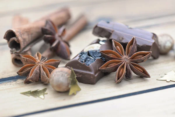 Рядом со звездой анисе с шоколадом и корицей на деревянном фоне — стоковое фото