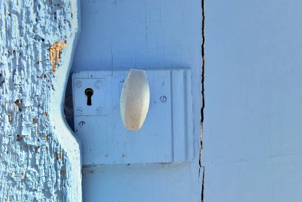 Sluiten op een handvat op een oude houten deur geschilderd in blauw — Stockfoto