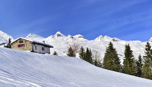 Cottage in beautiful snowy mountain under bleu sky — Stock Photo, Image