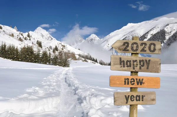 2020 gelukkig nieuwjaar geschreven op een postbord in de sneeuw op witte berg achtergrond — Stockfoto