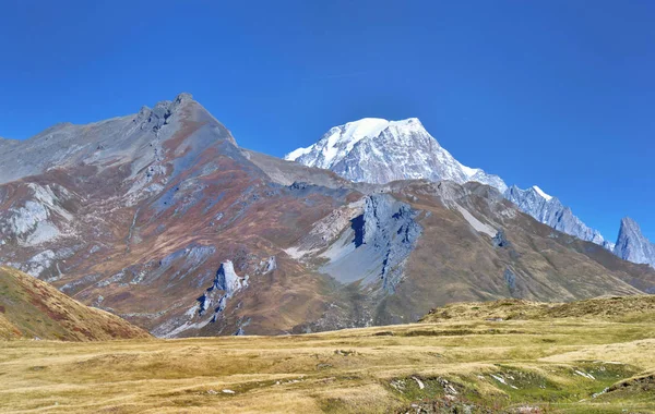 Vista sobre el Mont-Blanc detrás de la montaña rocosa cubierta de rojo bu — Foto de Stock