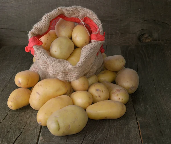 Potatis på en liten påse bland annat potatis på rustik trä b — Stockfoto