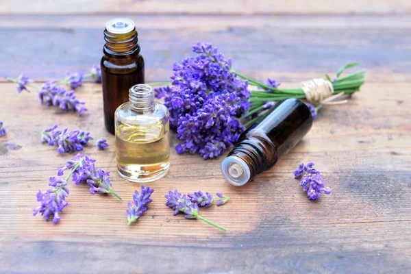 Botellas Aceite Esencial Ramo Flores Lavanda Dispuestos Una Mesa Madera —  Fotos de Stock