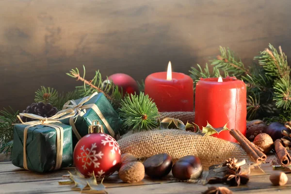 ろうそくやギフトで木製の背景に伝統的なクリスマスの装飾 — ストック写真