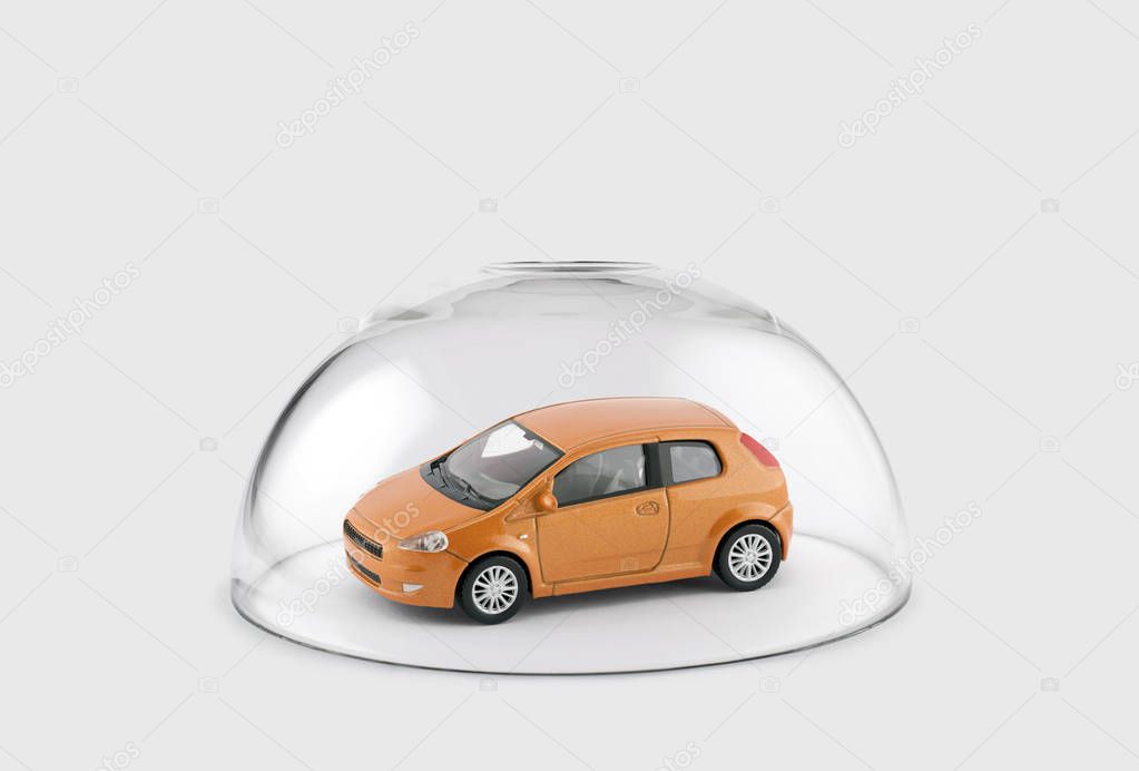 Orange car protected under a glass dome 