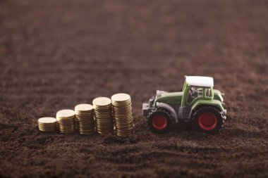 Traktör minyatür verimli topraklar arazi üzerinde paralar ile 