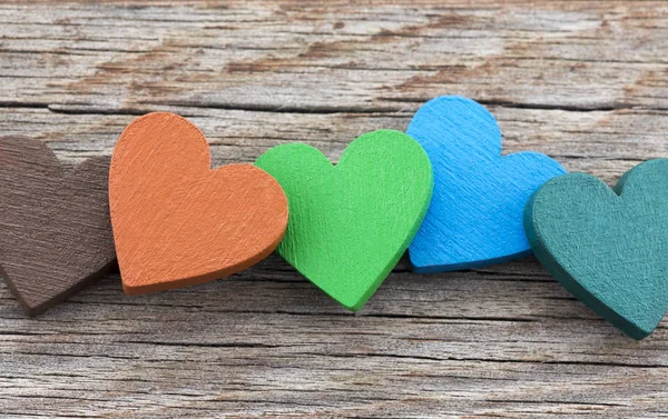 Ahşap arka planda renkli kalpler 