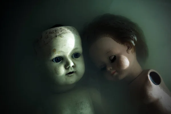黑暗肮脏的水中的恐怖娃娃 — 图库照片