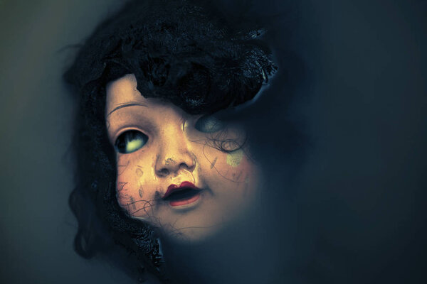 Creepy doll face in dark dirty water 