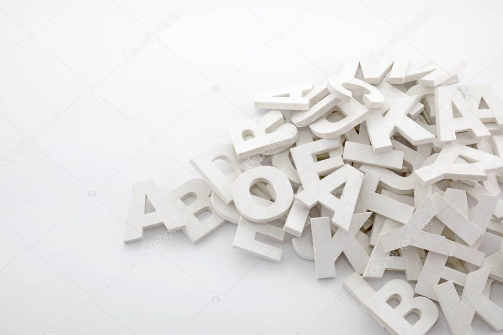 Pile of white painted wooden letters. Typography background composition. 