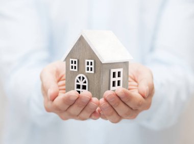 Ellerinde küçük ahşap oyuncak ev 