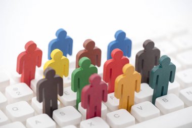 Bilgisayar klavyesindeki renkli insan figürleri grubu 