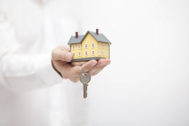 Elinde anahtarla sarı ev minyatürü 