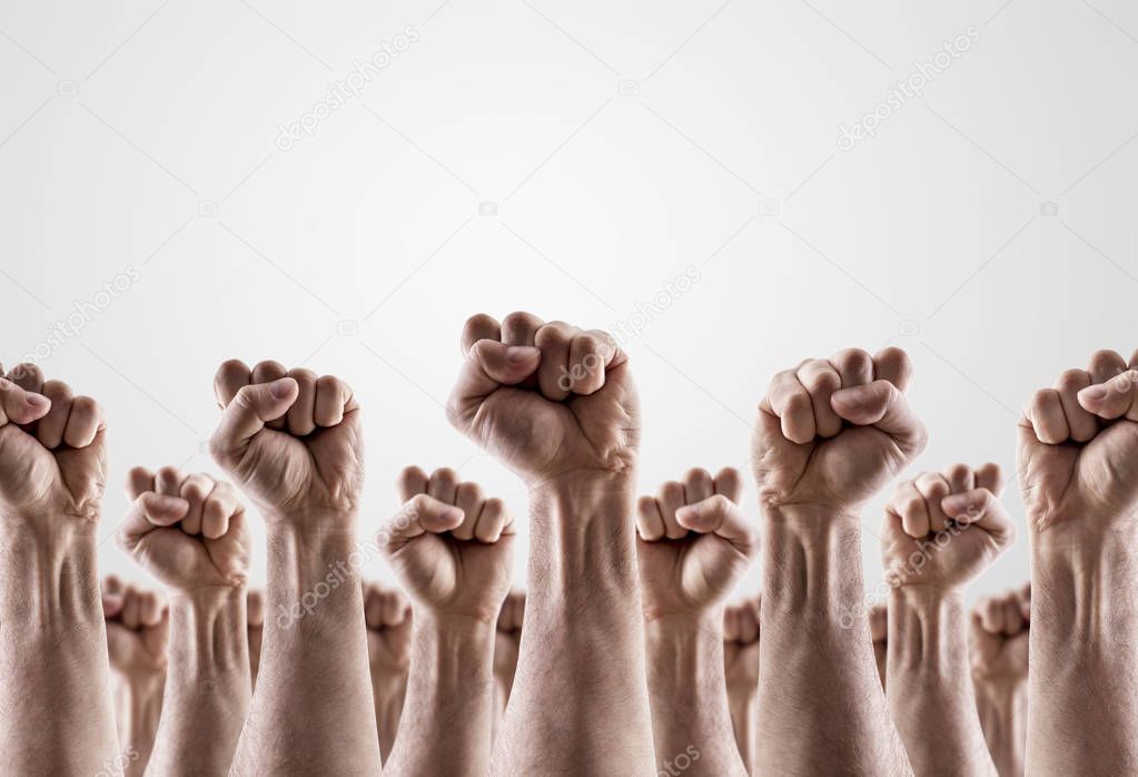 Large group of raised hands showing fists 